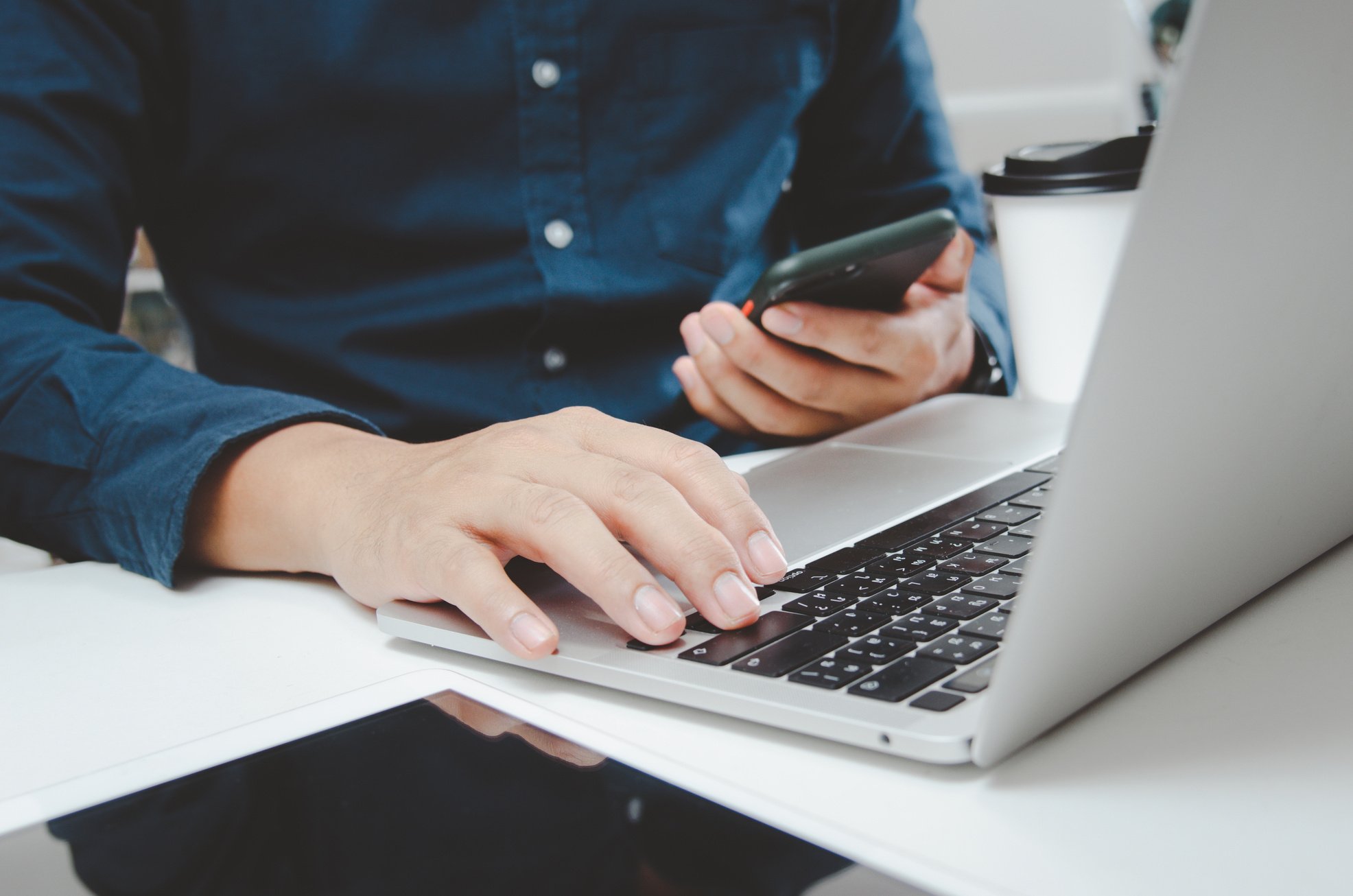 Businessman Using Smartphone and Laptop